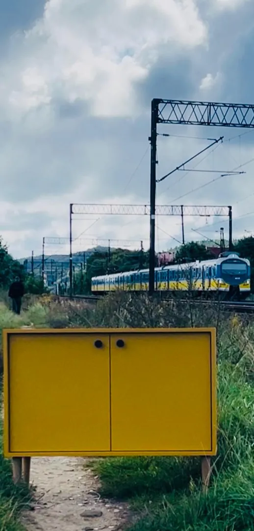 Żółta szafka przy torach kolejowych